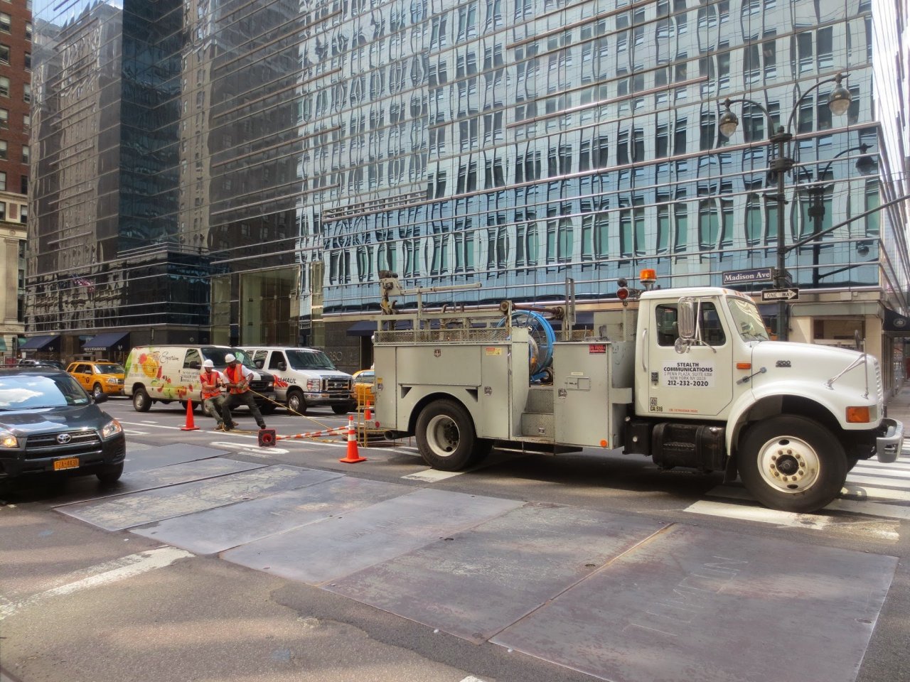 Stealth Communications utility truck parked beside a street construction site.
